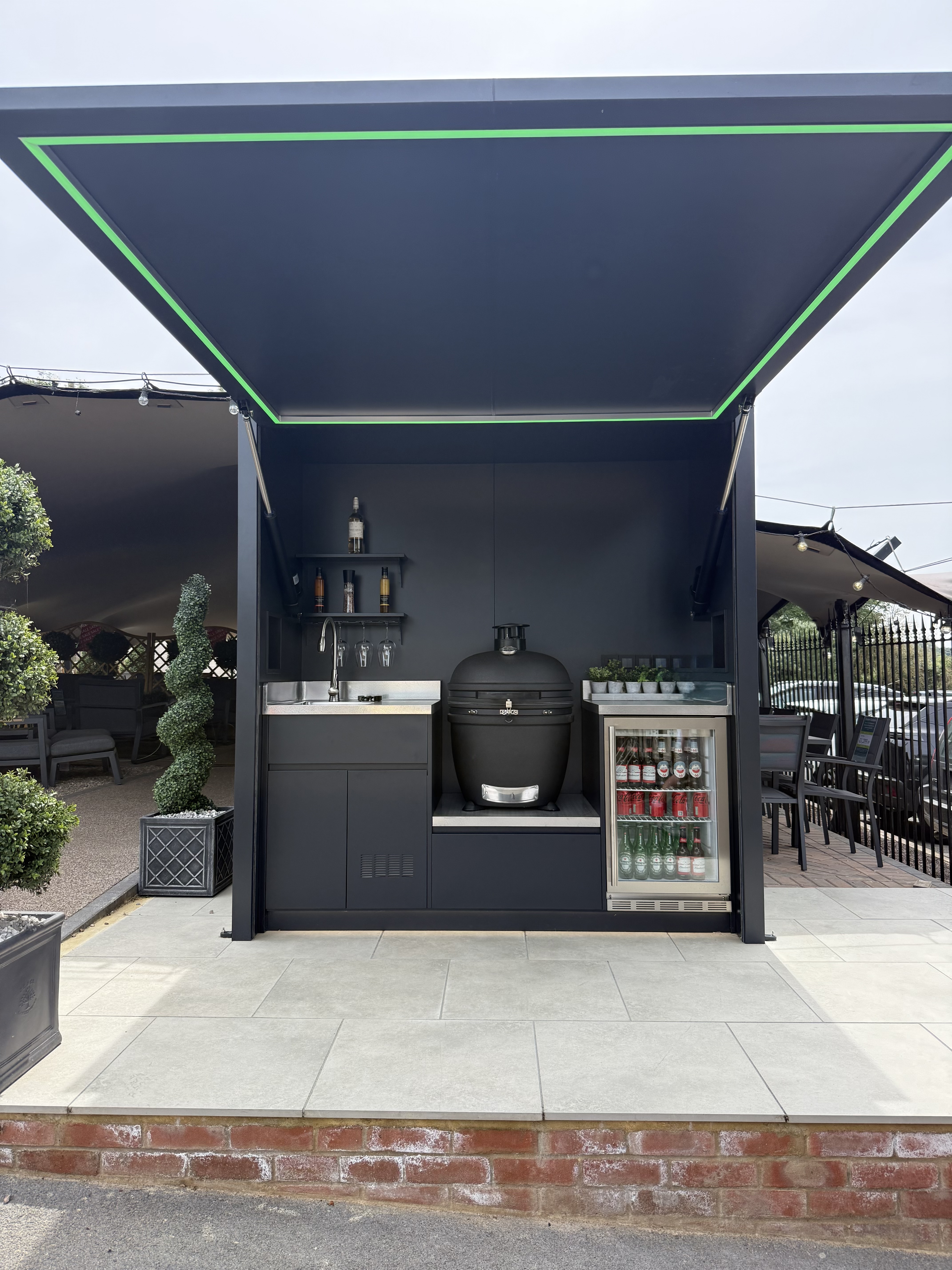 Black outdoor kitchen with green LED and Kamado style grill